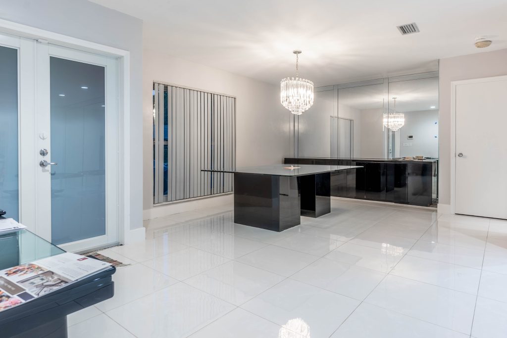 Elegant dining room with crystal chandelier and mirror wall in Plantation FL home