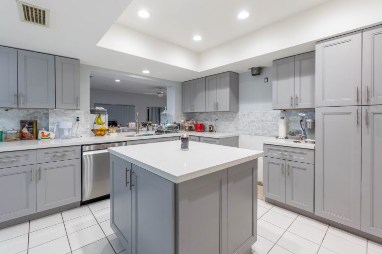 Large modern kitchen with gray cabinets, island, and stainless appliances