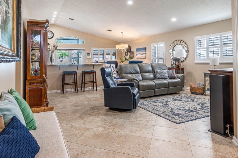 Well-staged open living room with vaulted ceiling in Lake Worth FL home
