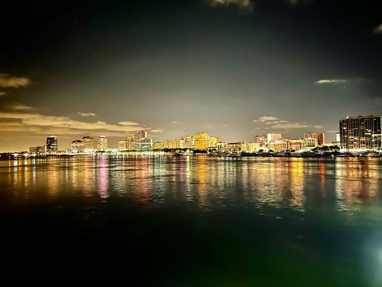 West Palm Beach city skyline reflecting over water at night