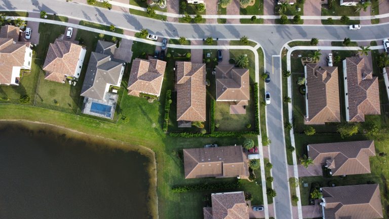 Top-down drone view of Florida neighborhood with pool and lake